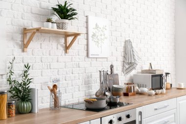 Mutfak tezgahında mutfak aletleri ve ürünleri var.