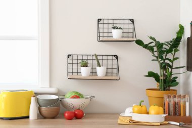 Mutfak tezgahında mutfak aletleri ve ürünleri var.