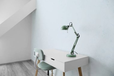 Boş odada lamba ve sandalye olan masa.