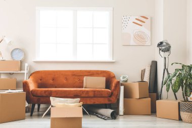 Taşındığı gün yeni dairede içinde eşyalar ve kanepe olan karton kutular.