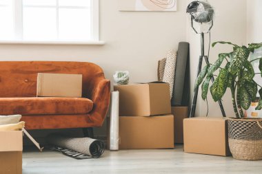 Taşındığı gün yeni dairede içinde eşyalar ve kanepe olan karton kutular.