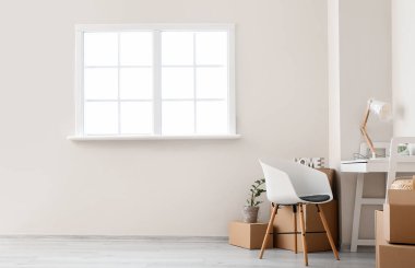 Taşındığı gün yeni dairede içinde eşyalar ve masa olan karton kutular.