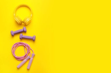 Dambıl ve kulaklıkla renk arkaplan üzerinde ip atlama