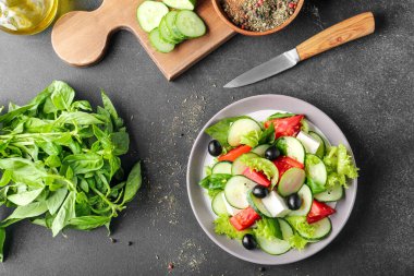 Koyu arkaplanda lezzetli salatalı tabak.