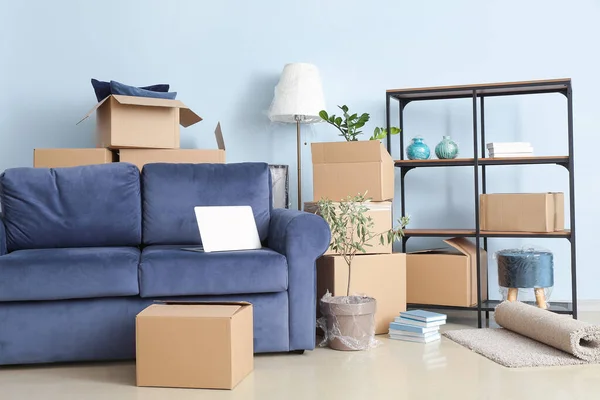 搬迁日新公寓内装有个人物品和沙发的纸板箱 — 图库照片