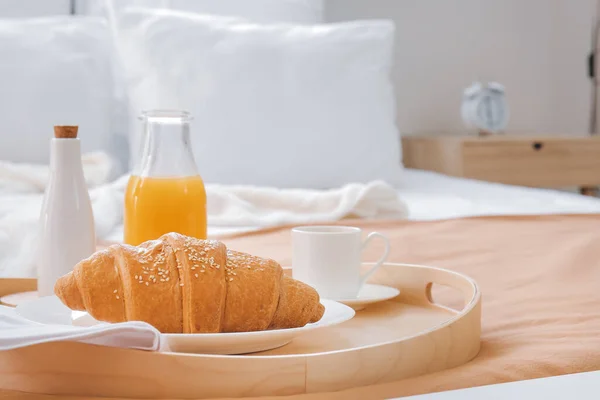 Tasty breakfast on bed in hotel room