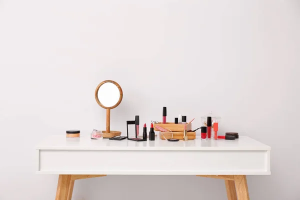 Set of makeup cosmetics with mirror on table