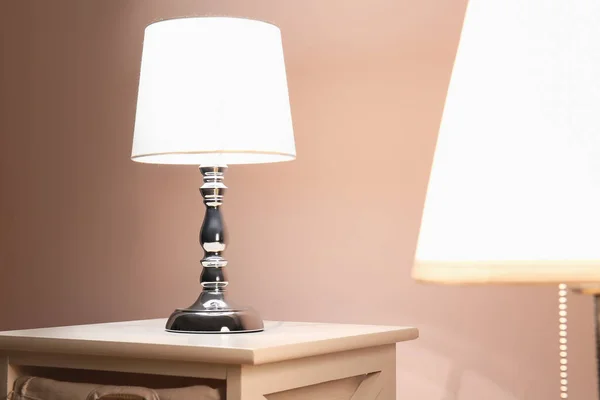 Glowing lamp on table in evening