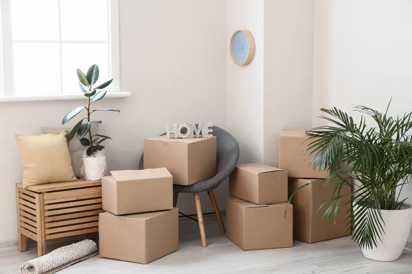 Cardboard boxes with belongings in new flat on moving day