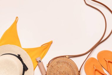 Hasır şapka, çanta ve açık arkaplanda plaj giysileri