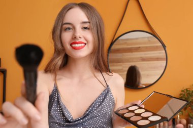 Soyunma odasında makyaj yapan genç bir kadın.