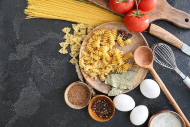 Koyu arkaplanda ürünleri olan kuru makarna.