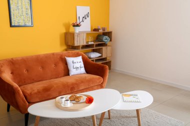 Rahat kanepesi ve masaları olan şık bir oturma odası.