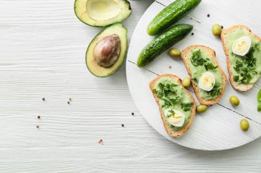 Masada lezzetli avokado sandviçleri olan bir pano.