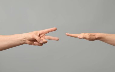 Gri arkaplanda roshambo oynayan insanlar