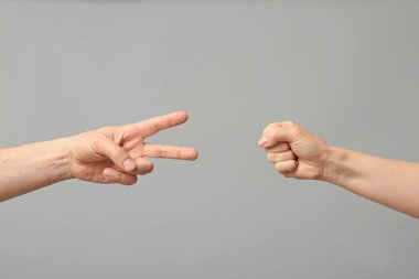 Gri arkaplanda roshambo oynayan insanlar