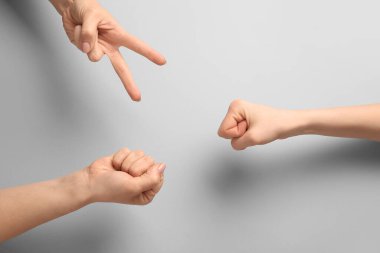 Gri arkaplanda roshambo oynayan insanlar