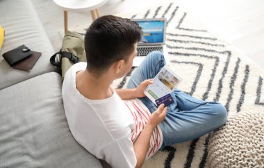 Evdeki otelde tablet bilgisayarlı rezervasyon odası olan bir adam.