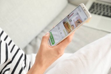 Otelde cep telefonu rezervasyonu yapan bir kadın.