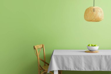 Masa ve sandalye renk duvarının yanında.