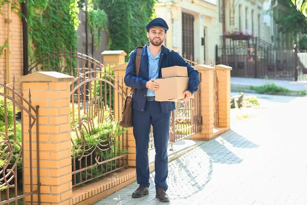 Jóképű Fiatal Postás Parcellákkal Szabadban — Stock Fotó