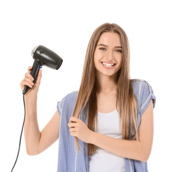 Beyaz arka planda saç kurutma makinesi olan genç bir kadın.
