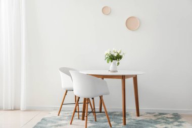 Masa ve sandalyeler ışık duvarının yanında.