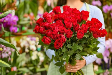 Dükkanında bir buket güzel kırmızı gül satan.