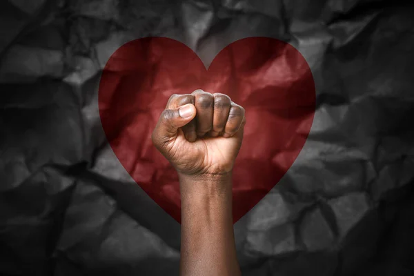 黑黑的背景下握紧拳头的非裔美国人的手 制止种族主义 — 图库照片