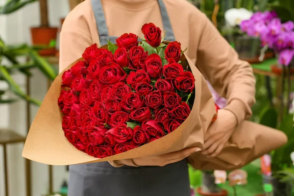 Sprzedawca Bukietem Pięknych Czerwonych Róż Sklepie — Zdjęcie stockowe
