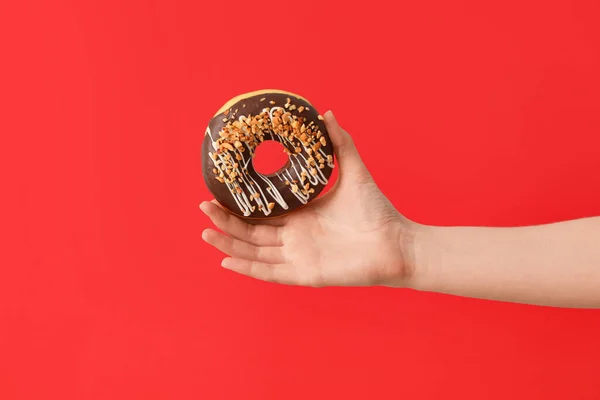 Hand Mit Leckerem Donut Auf Farbigem Hintergrund — Stockfoto
