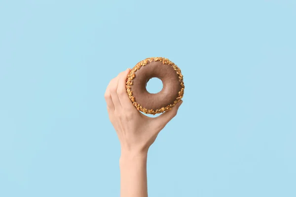 Hand Mit Leckerem Donut Auf Farbigem Hintergrund — Stockfoto