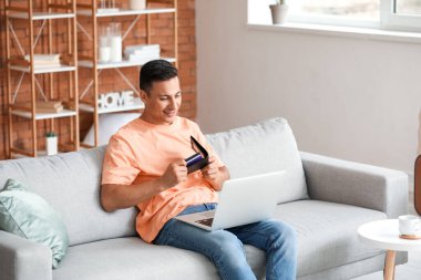 Bilgisayarlı bir adam evde online bilet ayırtıyor.