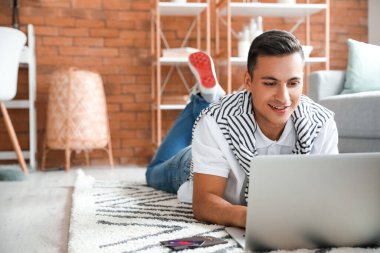 Bilgisayarlı bir adam evde online bilet ayırtıyor.