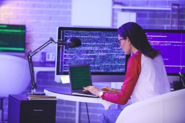 Geceleri ofiste çalışan kadın programcı.