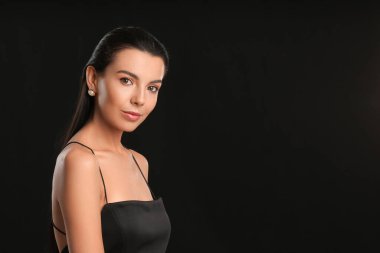 Koyu arkaplanda güzel göz farı olan genç bir kadın.