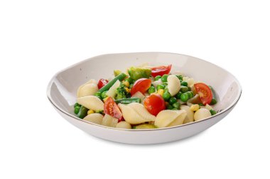 Beyaz arka planda lezzetli koni makarna ve sebzeli tabak.