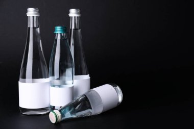 Karanlık arka planda temiz su şişeleri