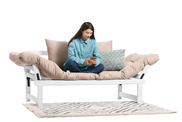 Mujer Joven Con Teléfono Móvil Sentado Sofá Sobre Fondo Blanco —  Fotos de Stock