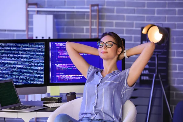 Portrait of female programmer in office at night