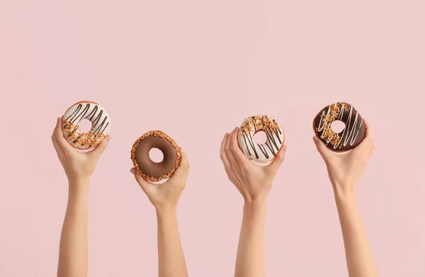 Hände Mit Leckeren Donuts Auf Farbigem Hintergrund — Stockfoto