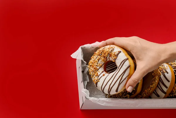 Frau Nimmt Leckeren Donut Aus Schachtel Auf Farbigem Hintergrund — Stockfoto