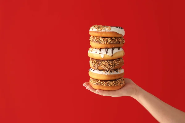 Hand Mit Süßen Leckeren Donuts Auf Farbigem Hintergrund — Stockfoto