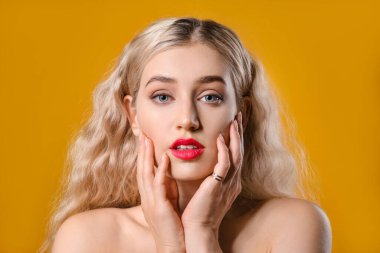 Renk arka planında parlak ruj olan güzel genç bir kadın.
