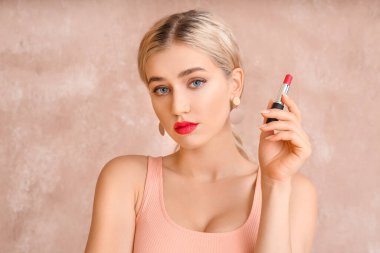 Renk arka planında parlak ruj olan güzel genç bir kadın.