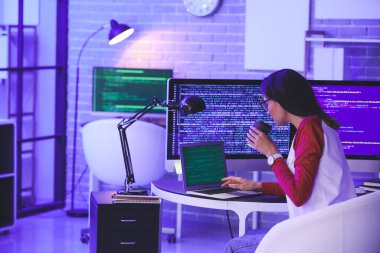 Geceleri ofiste çalışan kadın programcı.