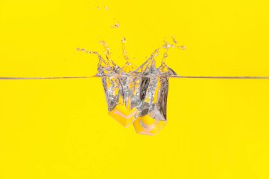 Buz küplerinin renk arkaplanındaki suya düşmesi