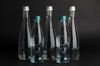 Karanlık arka planda temiz su şişeleri