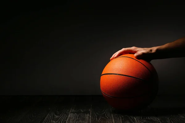 バスケットボールのためのボールと暗い背景に手 — ストック写真