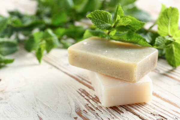 Fresh mint and soap on wooden background